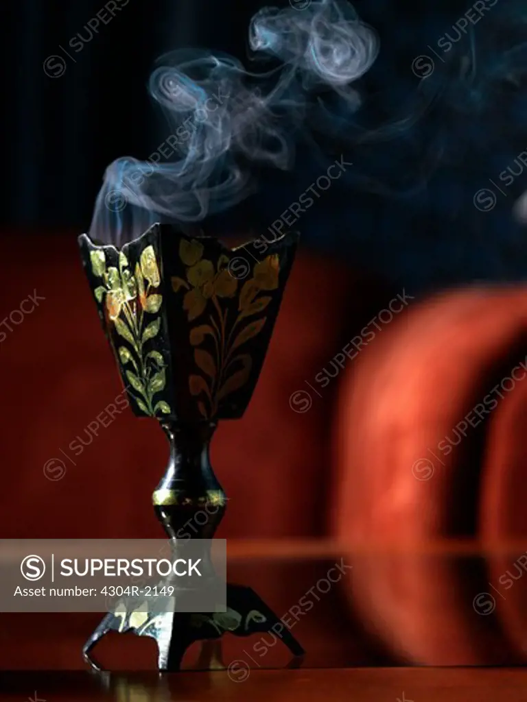 Full frame view of incense burner standing on the glass table.