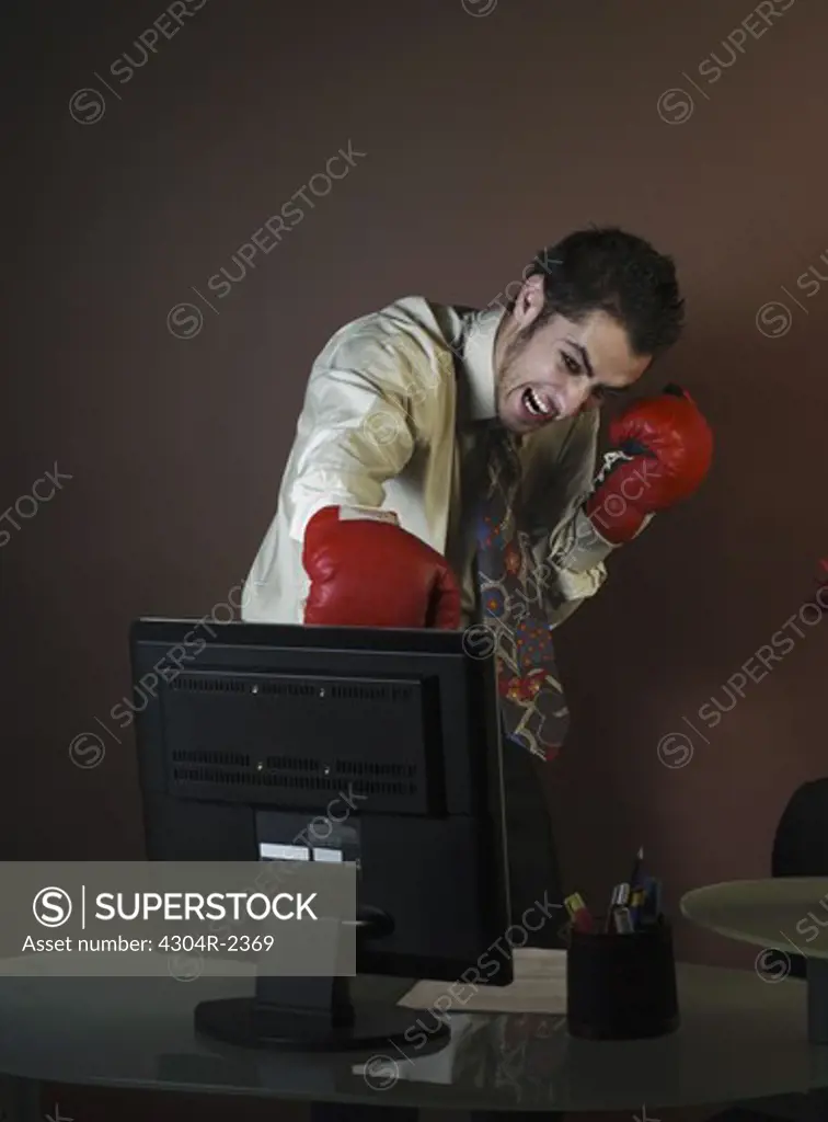 Young Businessman with boxing gloves attacking