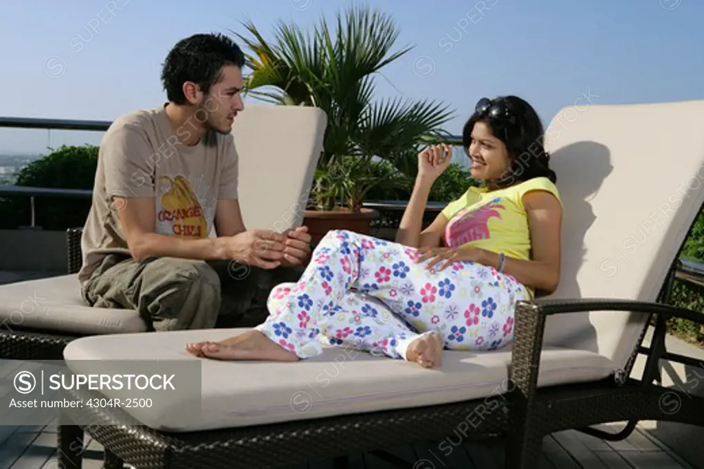 Young couple relaxing beside the pool.