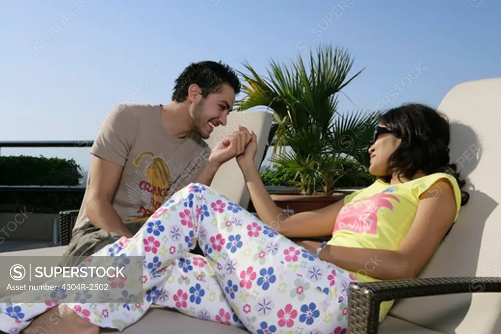 Young couple relaxing beside the pool.