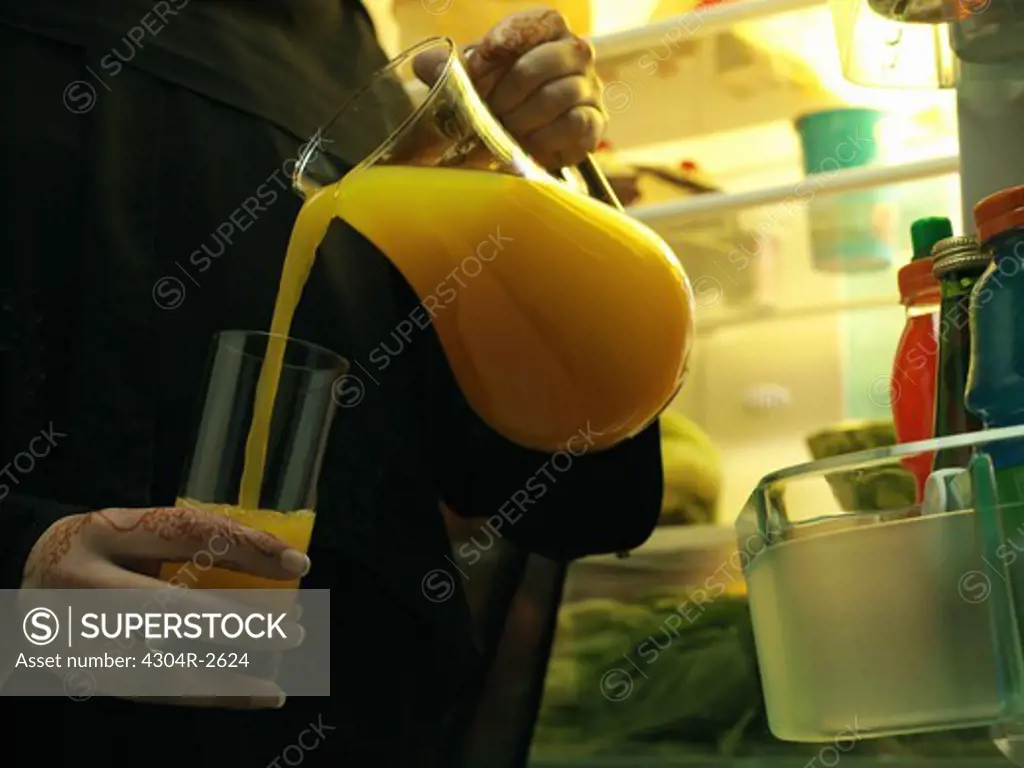 Arab lady pouring a juice in glass.