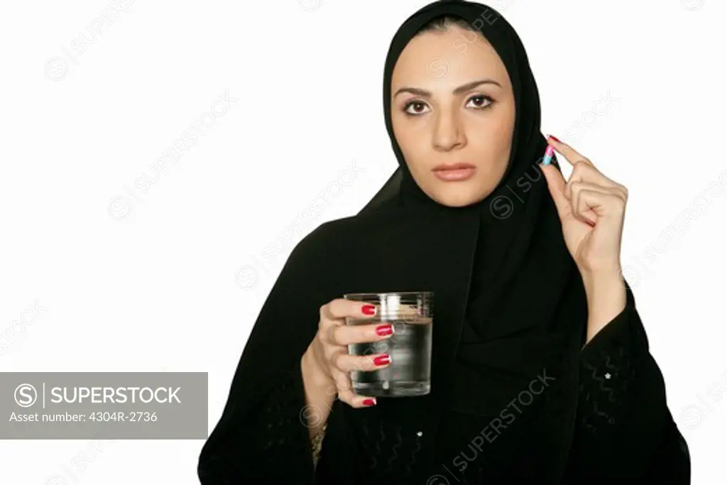 Arab lady taking a medicine.