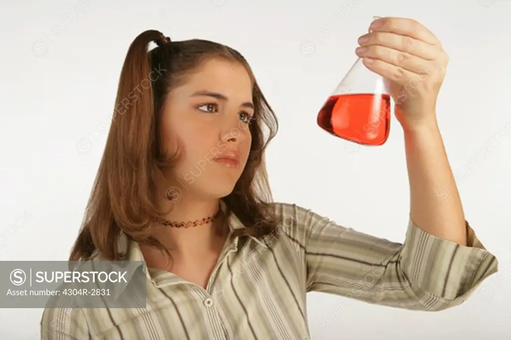 Young girl mix the chemicals in the laboratory.