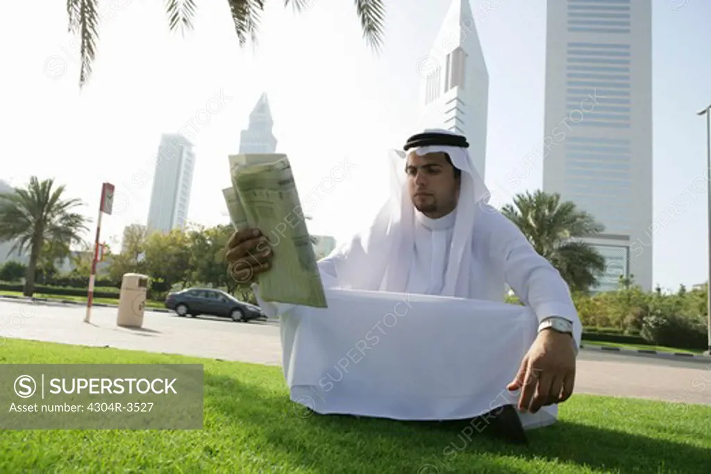 Arab Men read the newspaper under the Palm Tree
