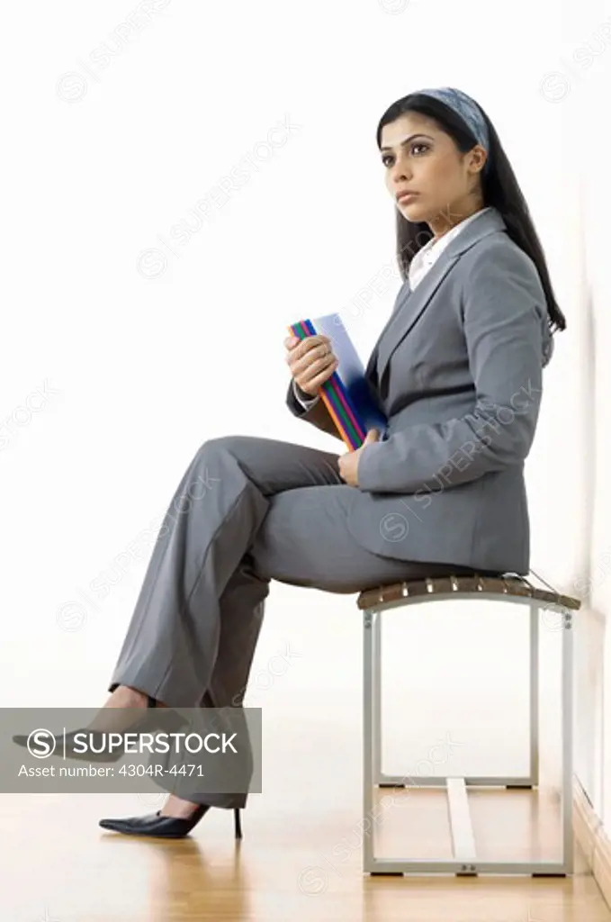 Lady holding documents, sitting on bench