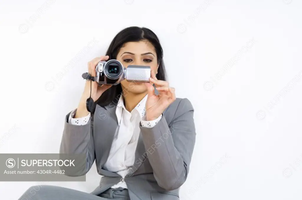 Lady sitting on a bench, holding a video camera
