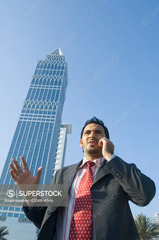 Young man talking on cell phone with skyscrapers in the background