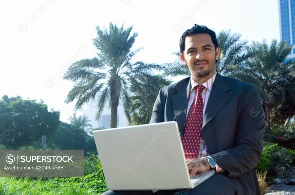 Young man with a laptop computer outdoors
