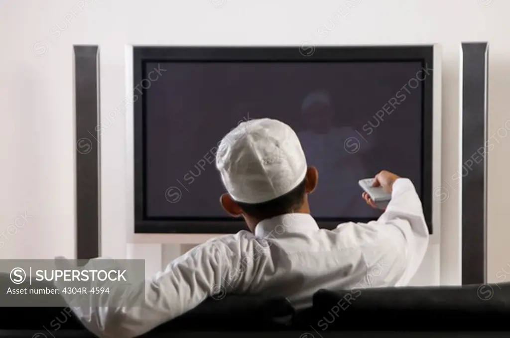 Young Arab man watching TV