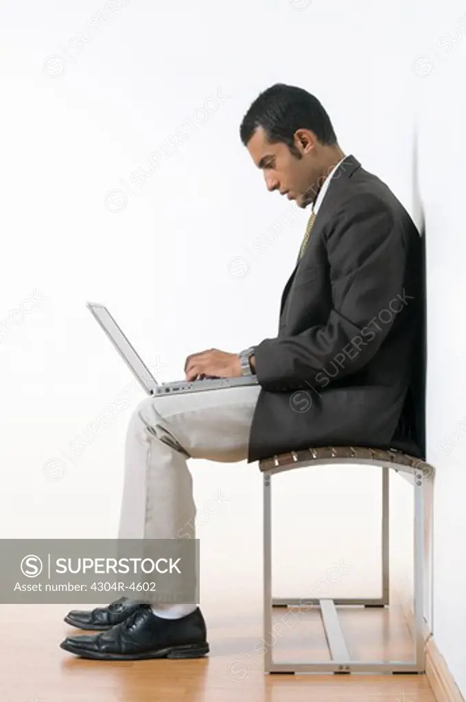 Young man sitting with a laptop computer
