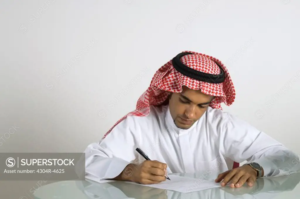 Young Arab man working at table