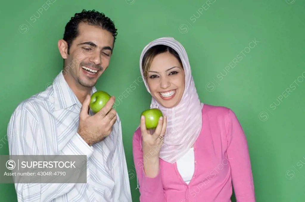 Couple holding green apple