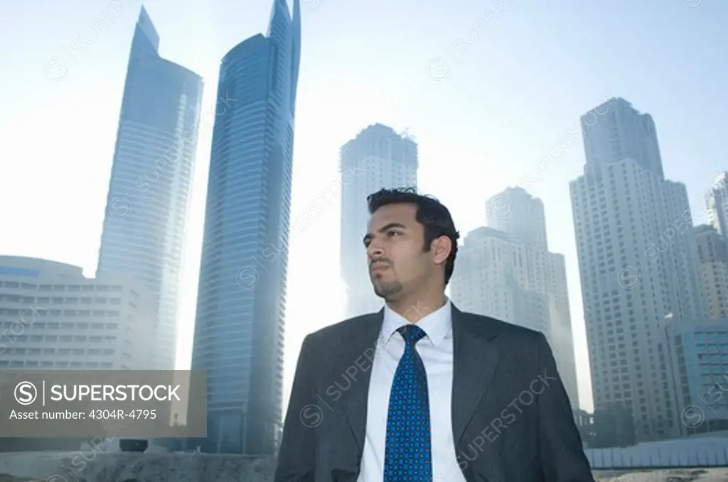 Businessman in front of towers seen through the mist
