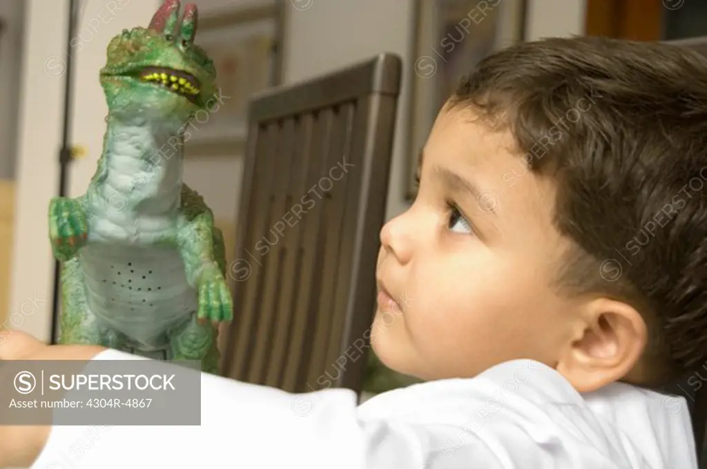 Young Boy playing with a toy dinosaur