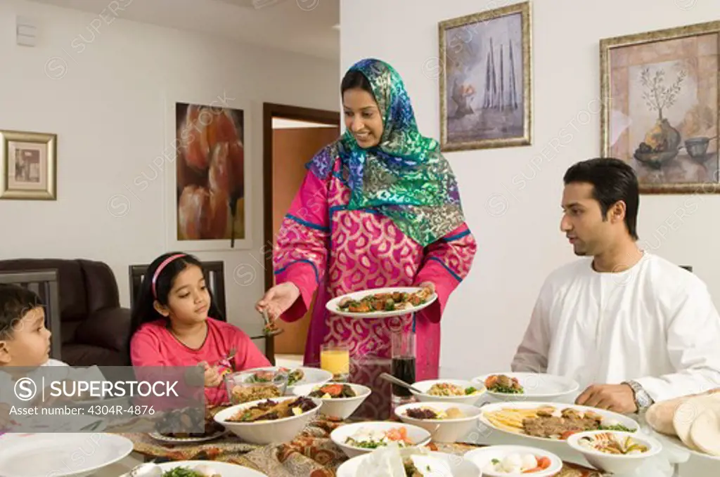 Mother serving food to family