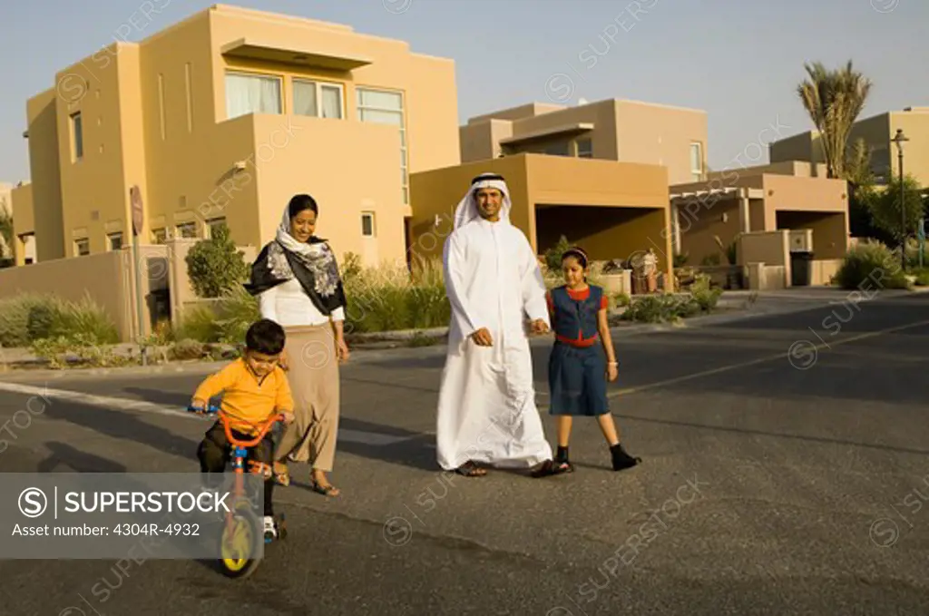 Family of four walking outside their home