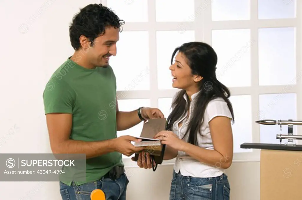 Young couple deciding curtain color for home improvement