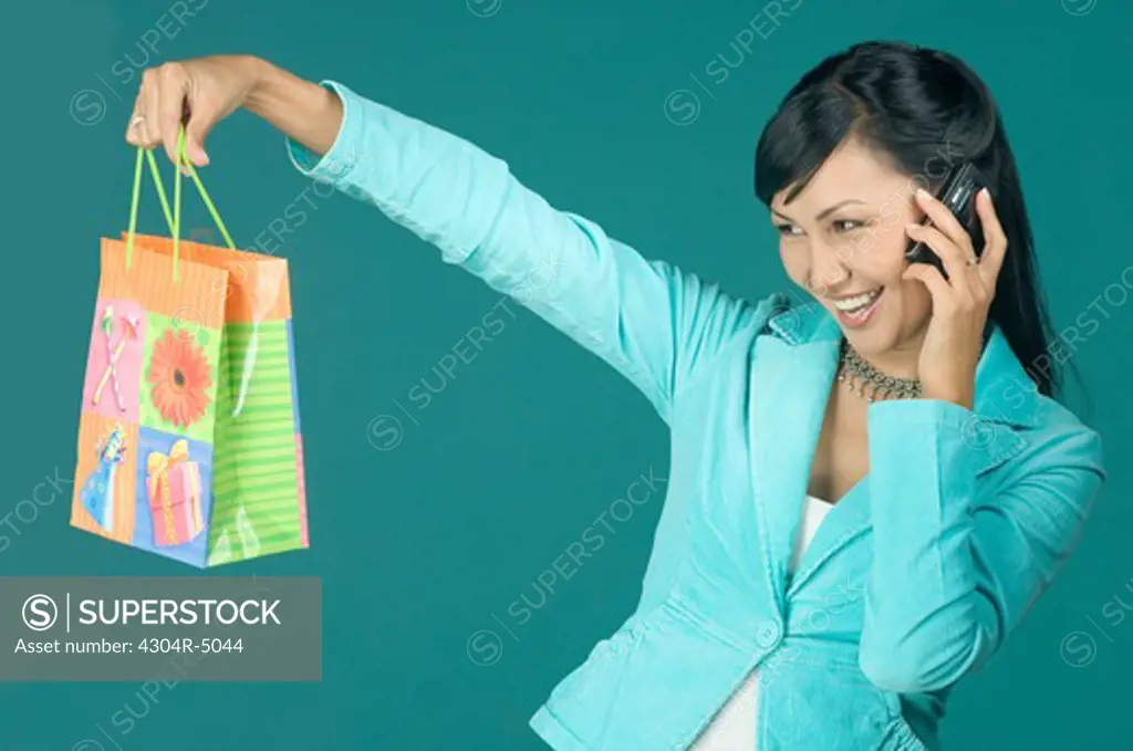 Young woman with cell phone and shopping bag