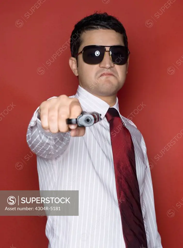 Portrait of a young man holding a gun