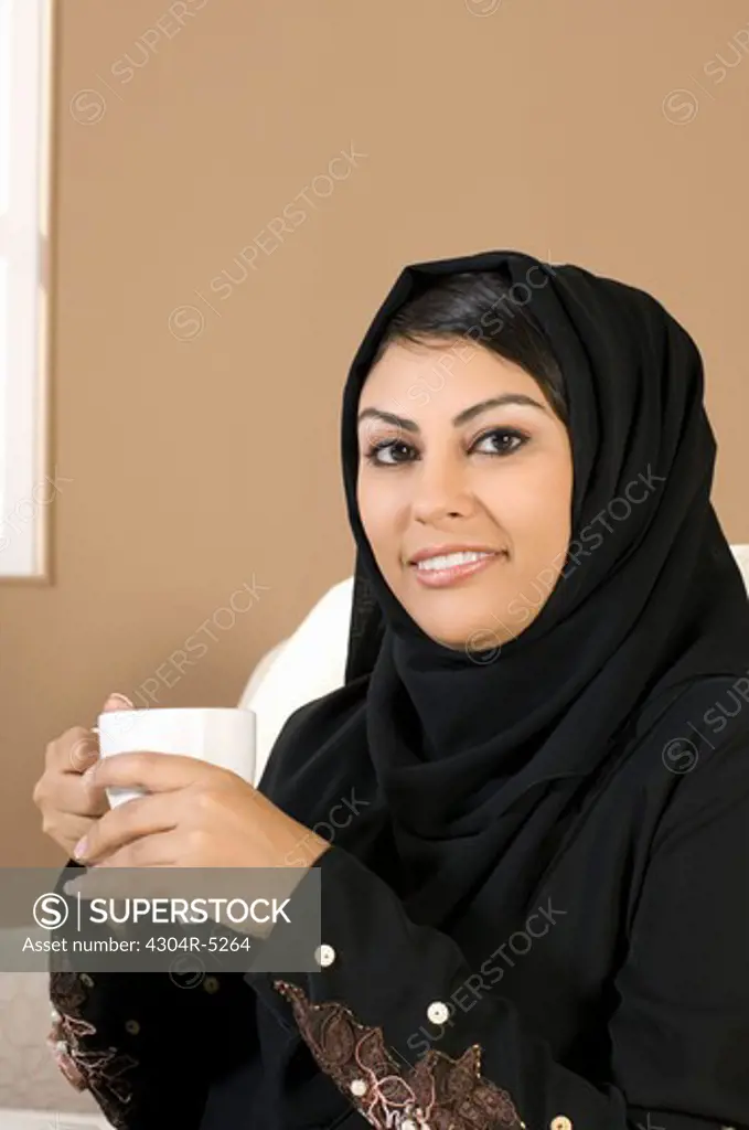Young woman holding mug, portrait