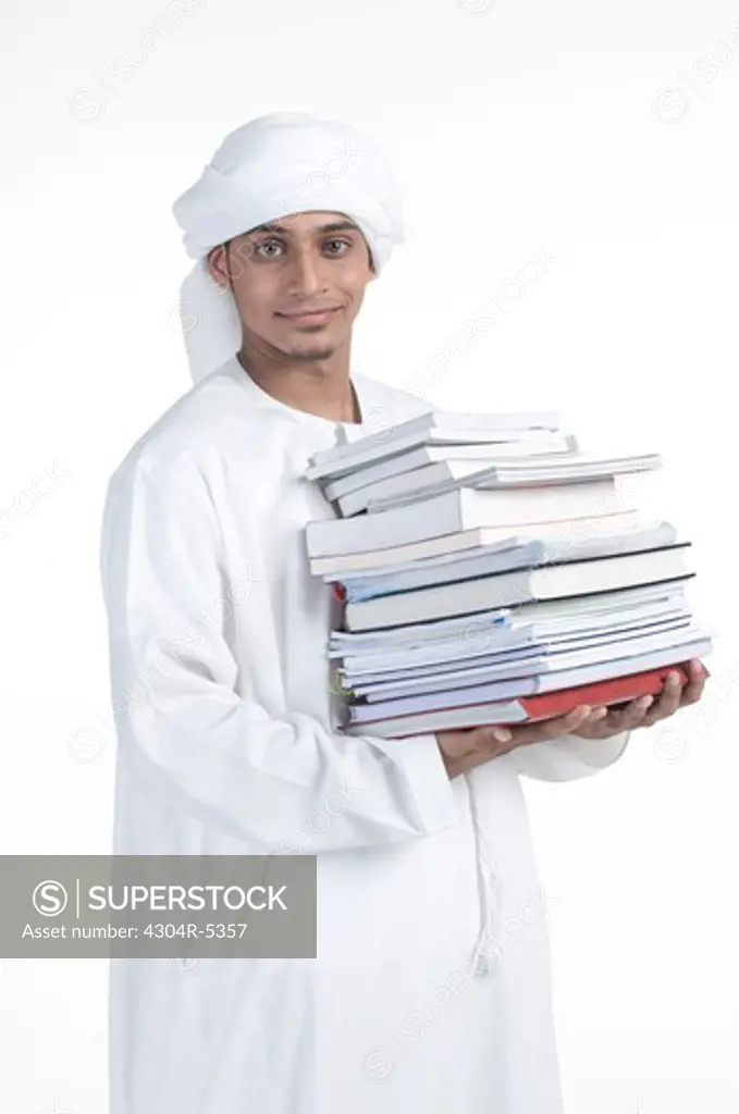 Young man carrying pile of books, portrait