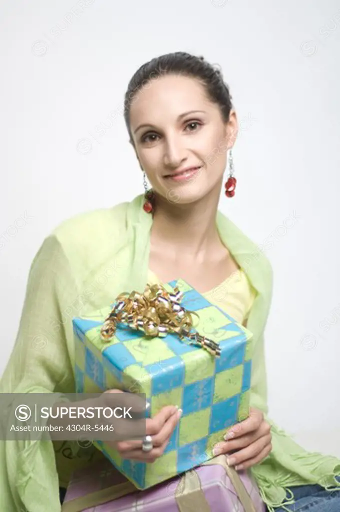 Young woman holding gift box, portrait