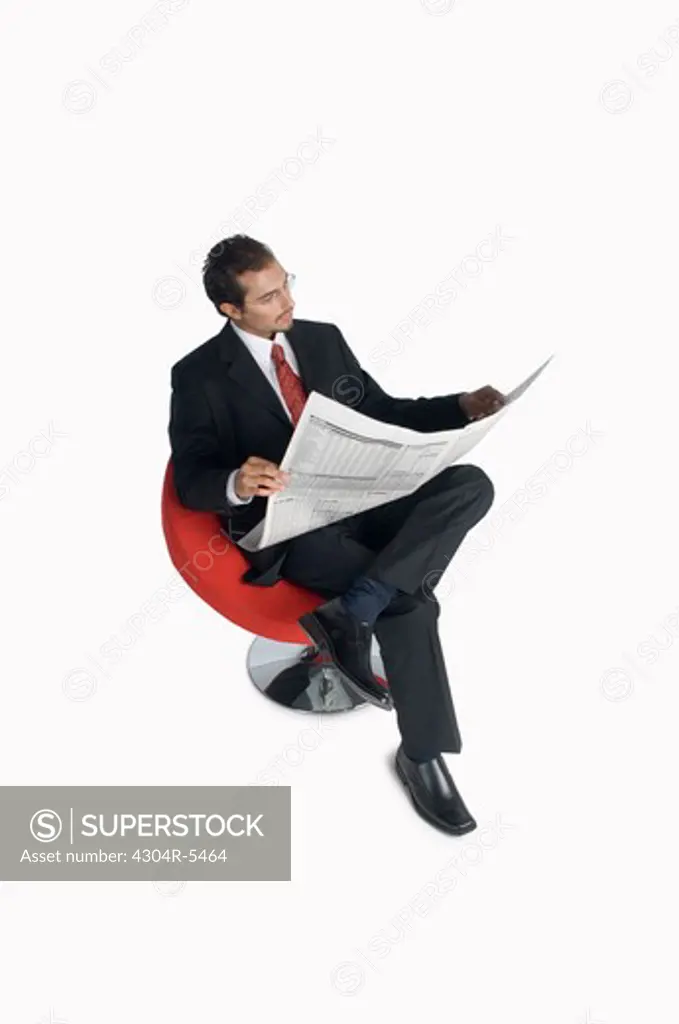 Businessman reading newspaper, elevated view