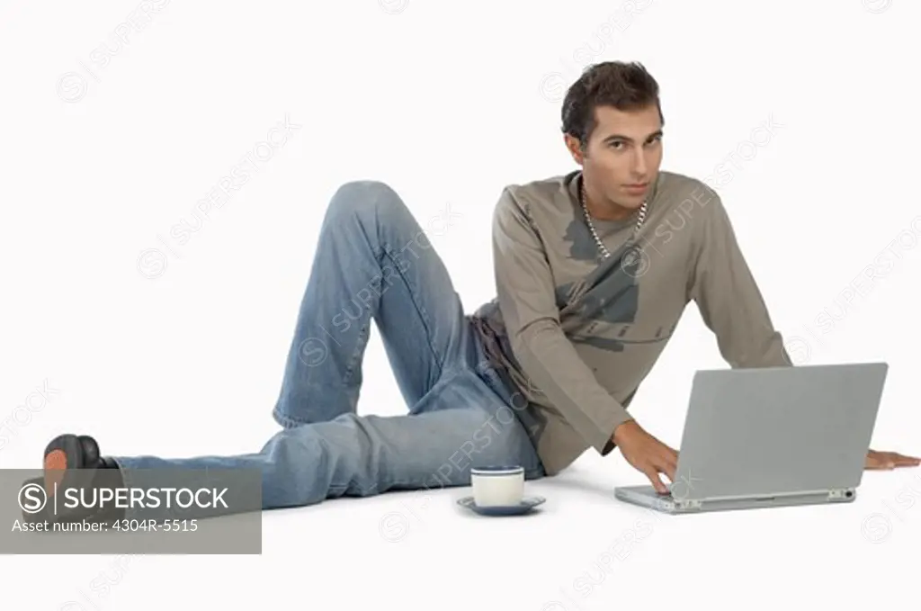 Young man using laptop, portrait