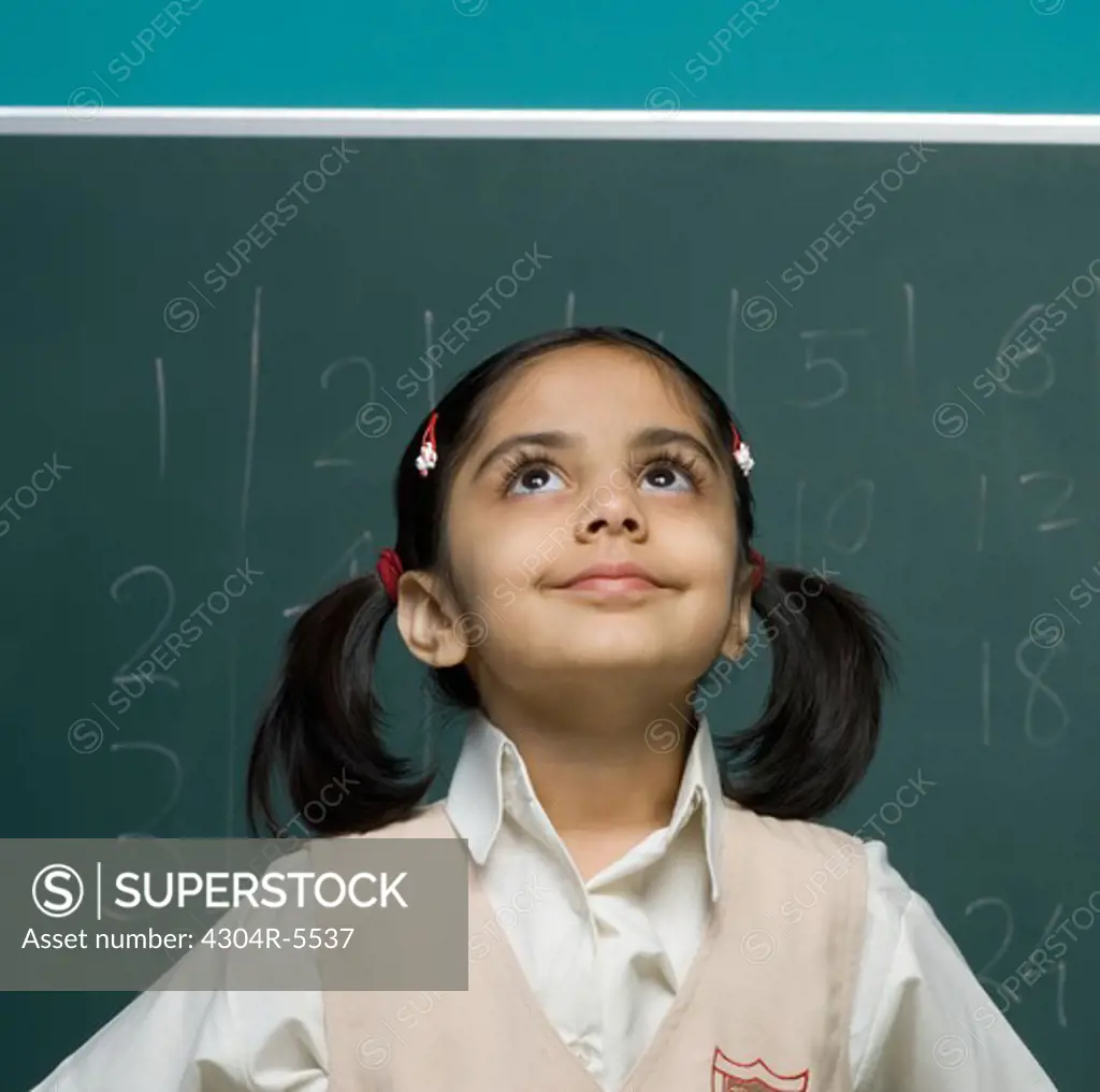 Girl (6-7) in classroom, looking up
