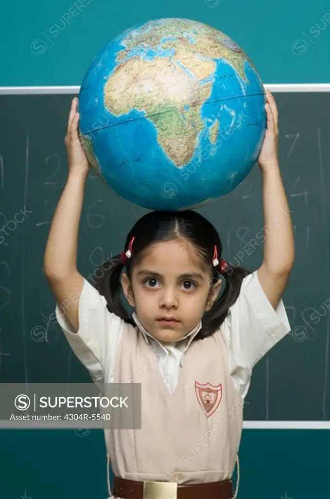 Girl (6-7) carrying globe over her head