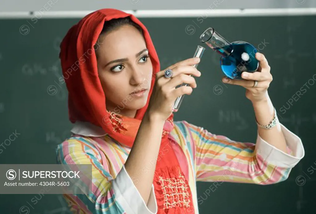 Teacher holding measuring tubes, close-up