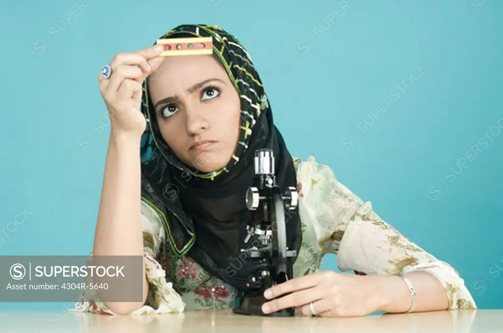Woman with microscope looking at microscope slide