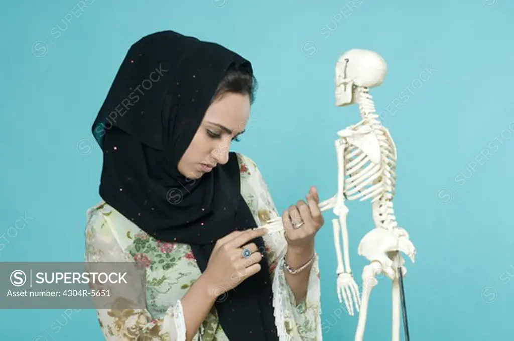 Woman holding human skeleton, close-up