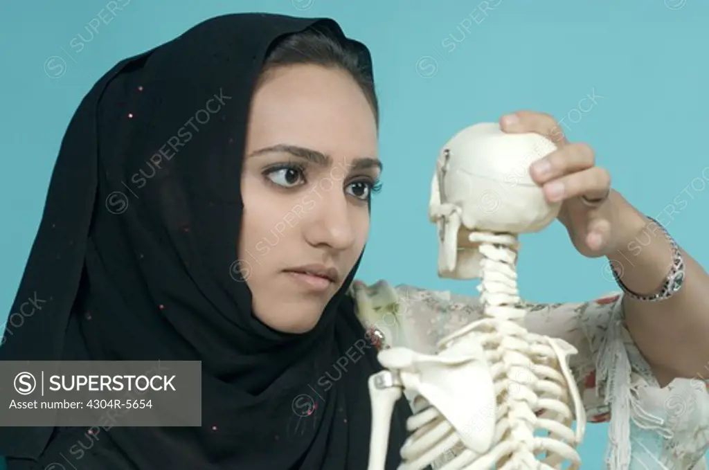 Woman holding human skeleton, close-up