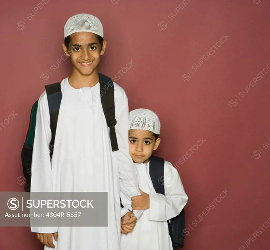 Brothers carrying shoulder bags, portrait, smiling