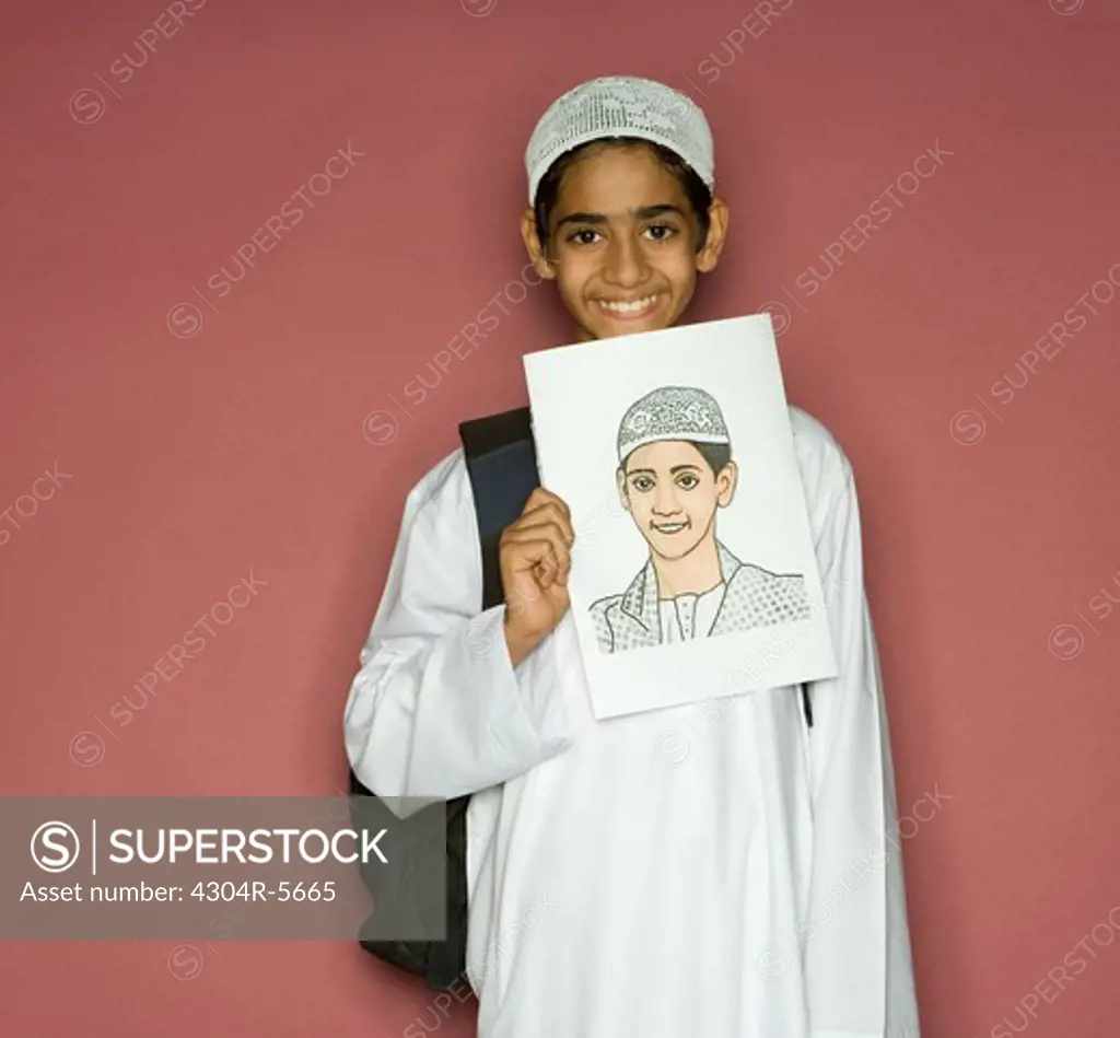 Boy (10-11) holding painting, smiling, portrait