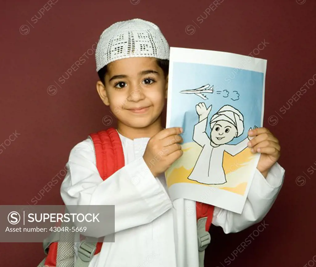 Boy (8-9) holding painting, smiling, portrait