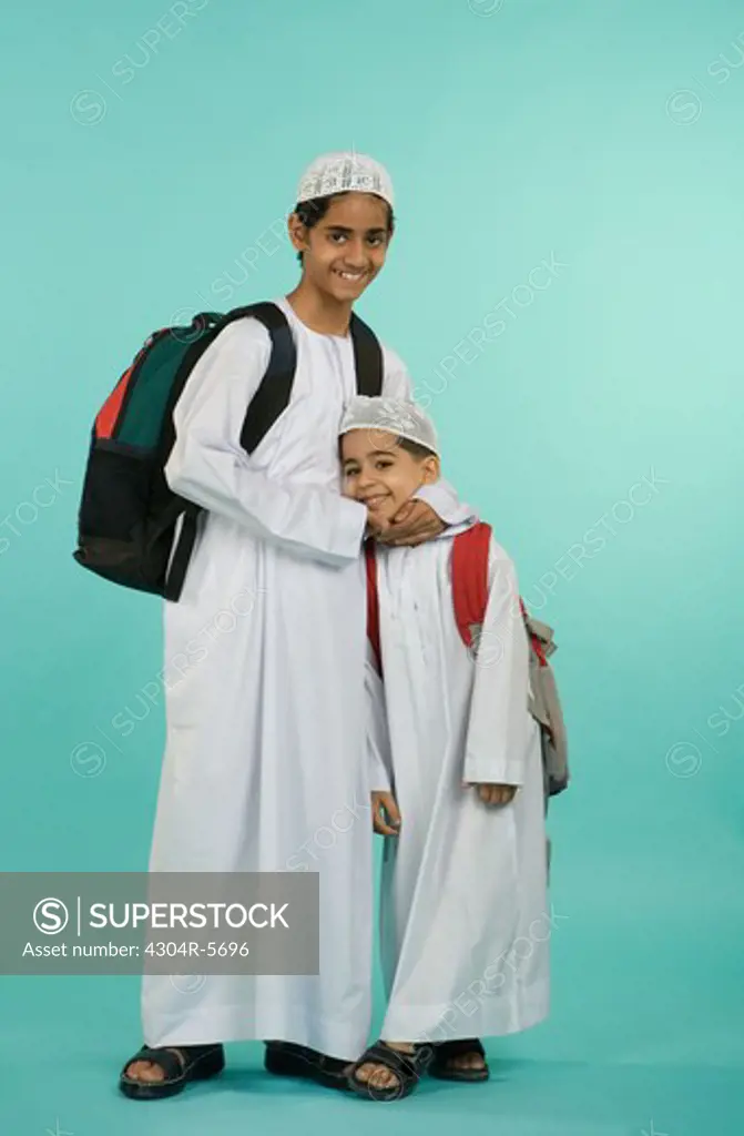 Brothers carrying shoulder bags, portrait, smiling