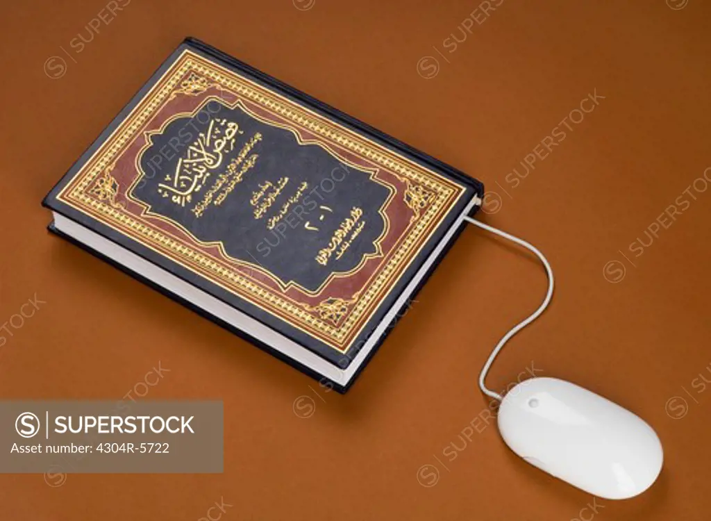 Computer mouse wire used as bookmark in book,close-up,elevated view