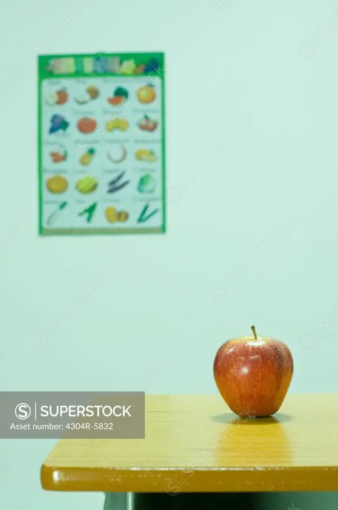 Apple kept on table in classroom, close-up