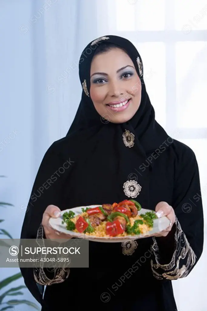 Young woman holding food in plate, portrait