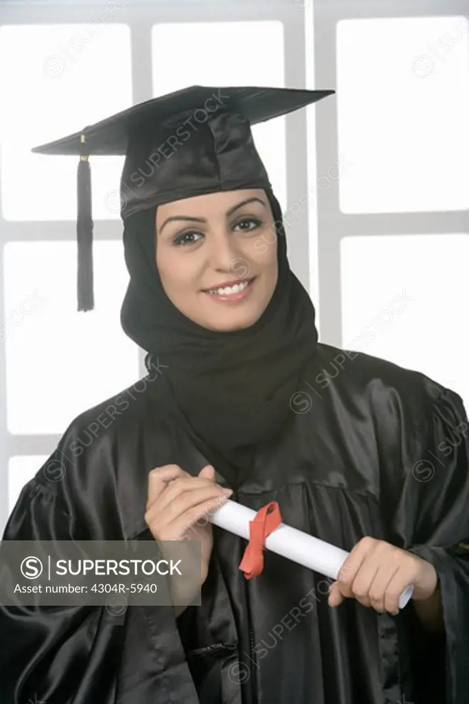 Young woman holding diploma, close-up, portrait