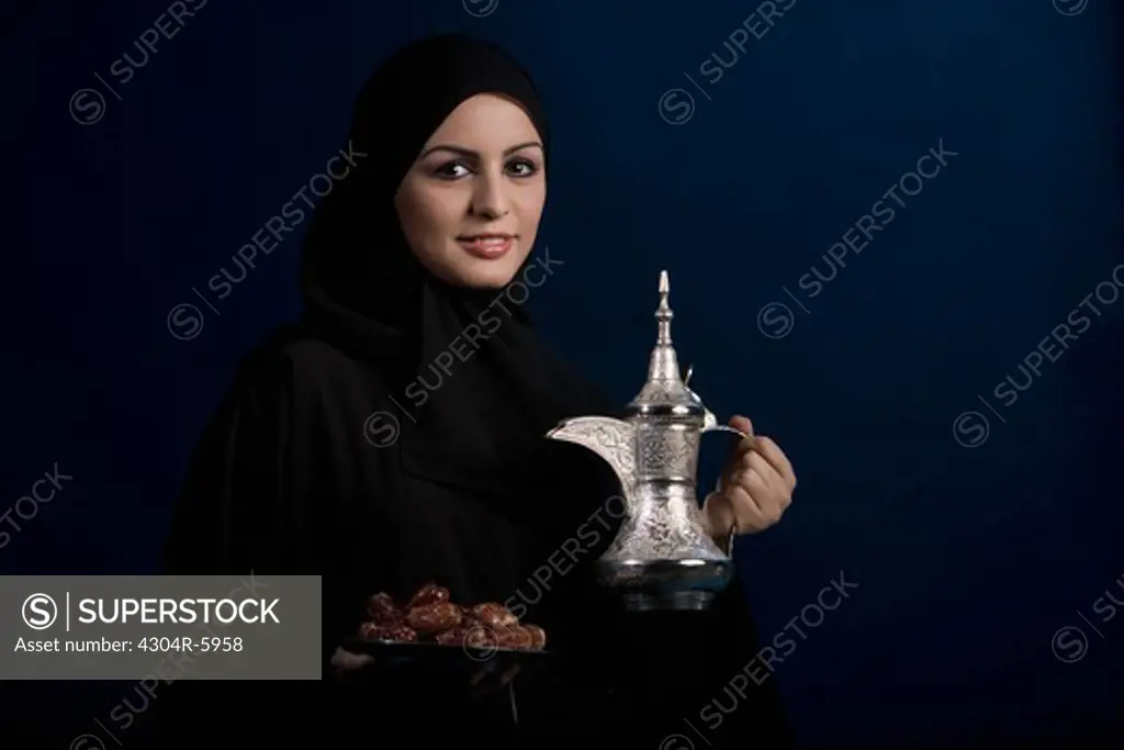 Young woman holding plate and jug, close-up, portrait
