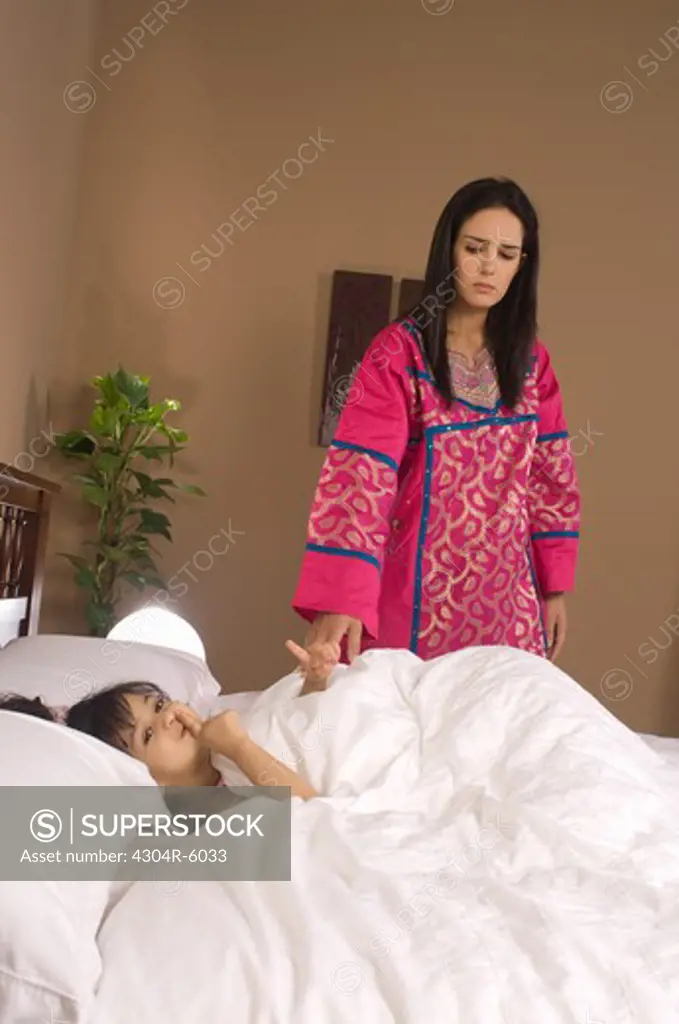 Mother looking at daughter (3-4) in bedroom