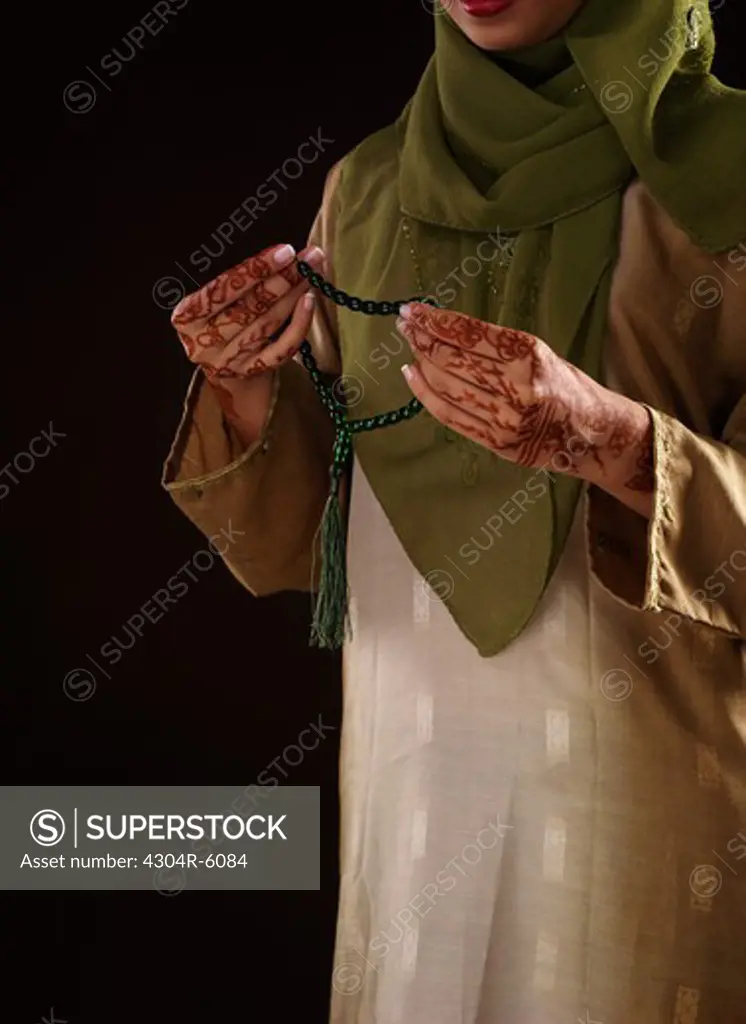 Young woman holding prayer beads, close-up