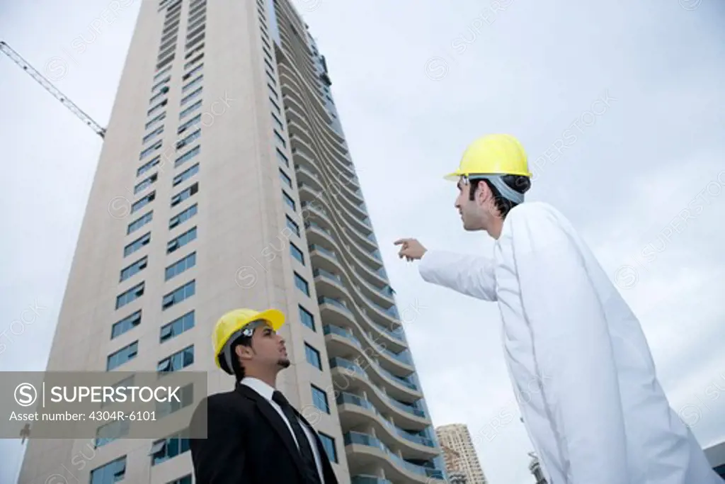 Businessman pointing at building, low angle view