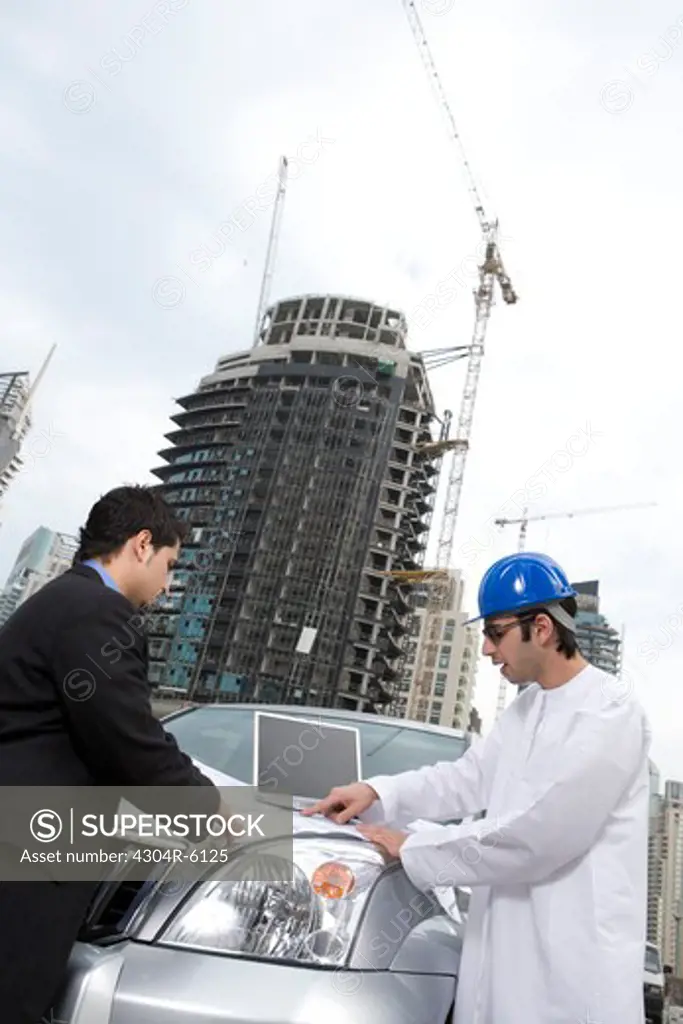 Businessmen conversing at construction site