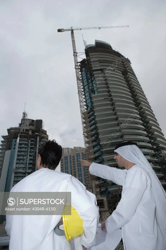 Businessmen discussing with buildings in background
