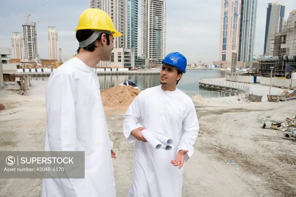 Businessmen in Dishdash at construction site with layouts