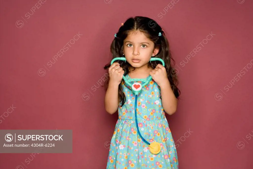 Girl holding stethoscope, portrait